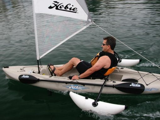 A person sails a Hobie kayak with a Mirage Sail Kit and the Sidekick AMA kit