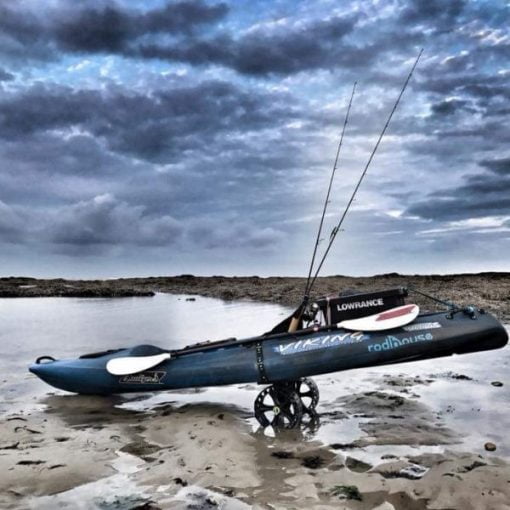 A fishing kayak strapped to a Railblaza C-Tug Cart with SandTrakz wheels