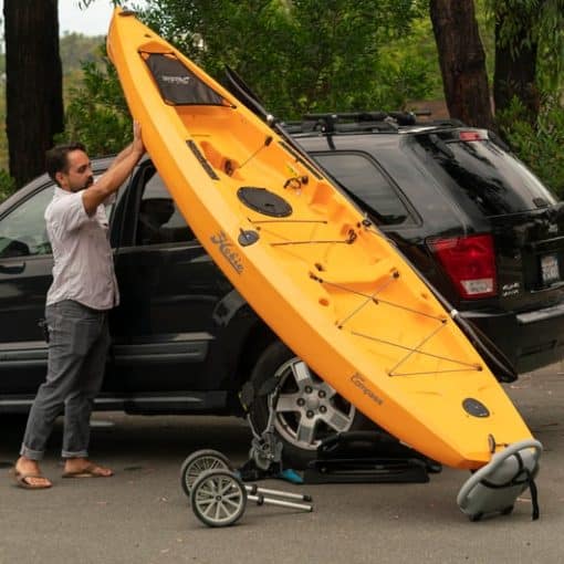 A person uses the Hobie Compass Loader to assist in manoeuvring a Hobie Compass fishing kayak on to a car's roofracks