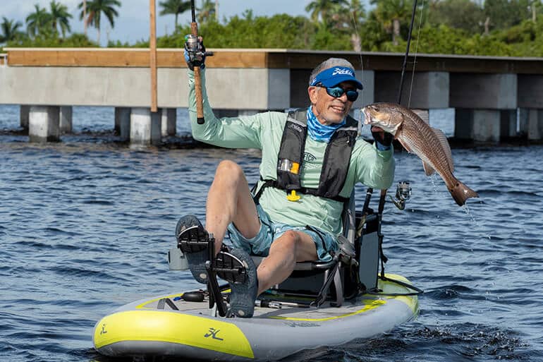 Steve Fields landing a fish aboard his Hobie iTrek 9 Ultralight inflatable fishing kayak. Image credit Florida Sportsman