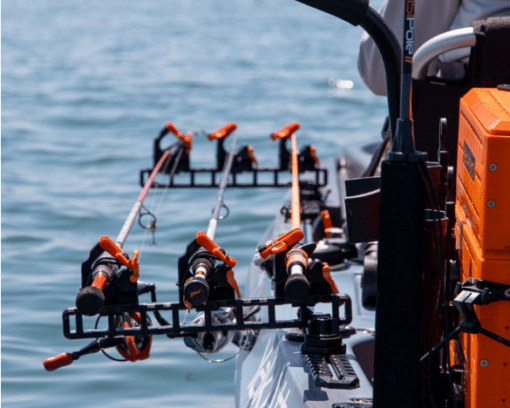 YakAttack Sidestage track mounted horizontal rod rack system shown installed on a fishing kayak and housing three fishing rods